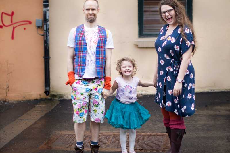 The family holding hands and looking happy